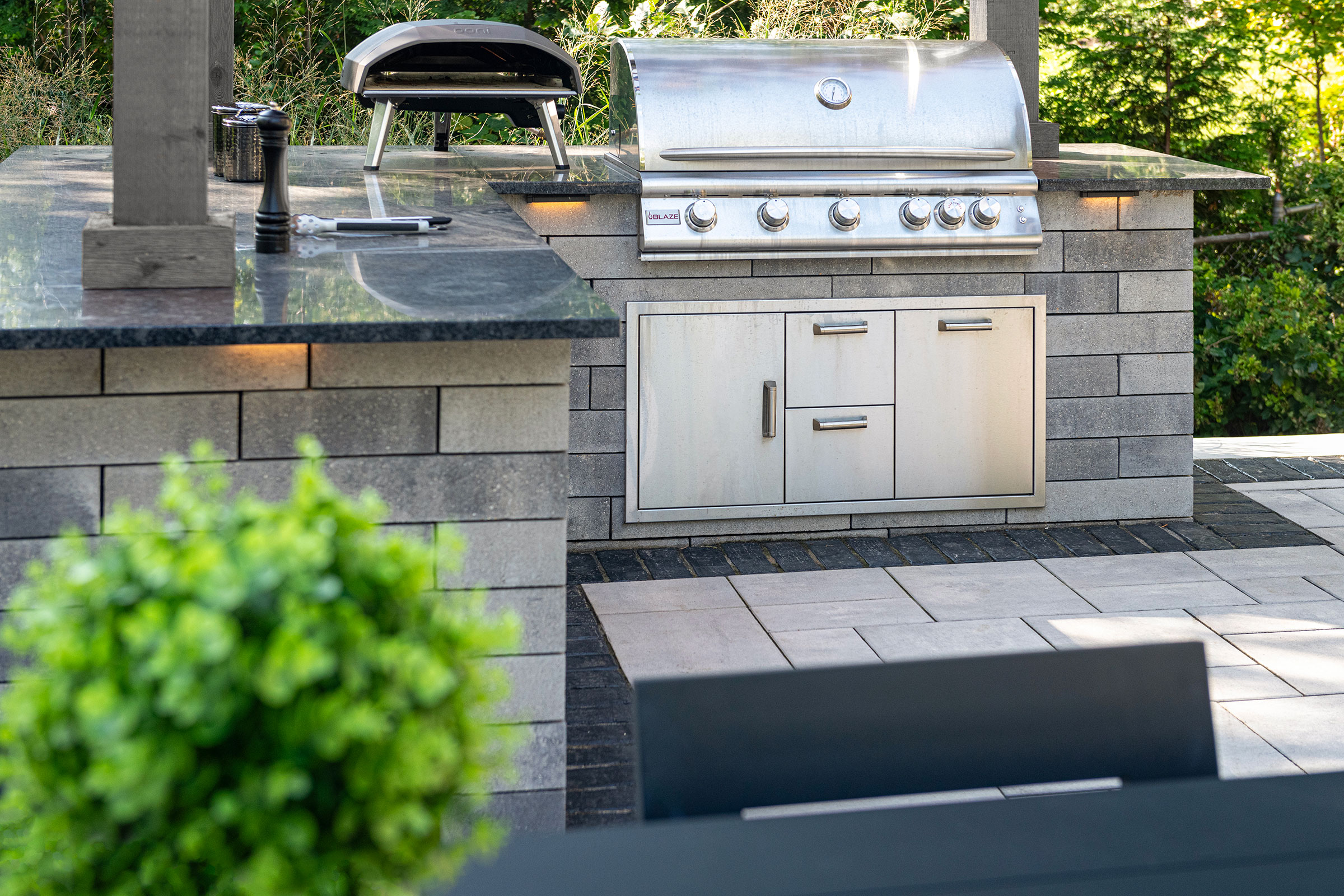 Outdoor kitchen with masonry base and stainless grill